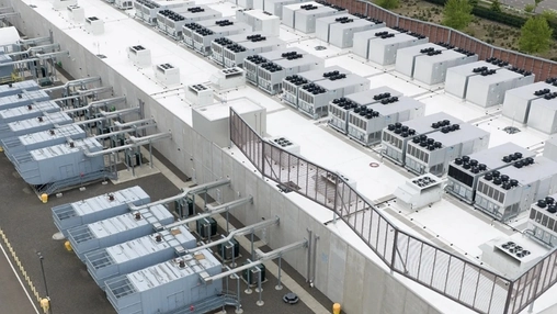 Overhead shot of a data centre facility showing multiple white HVAC units and cooling equipment on a flat roof