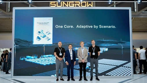 Attendees gather beneath a Sungrow display screen at a renewable energy trade show